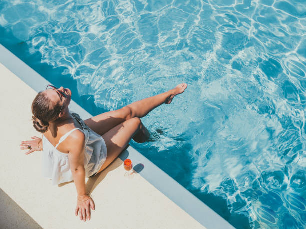 girl sitting on the edge of swimming pool